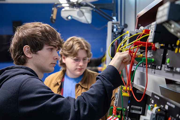 students working on board with electrical circuits