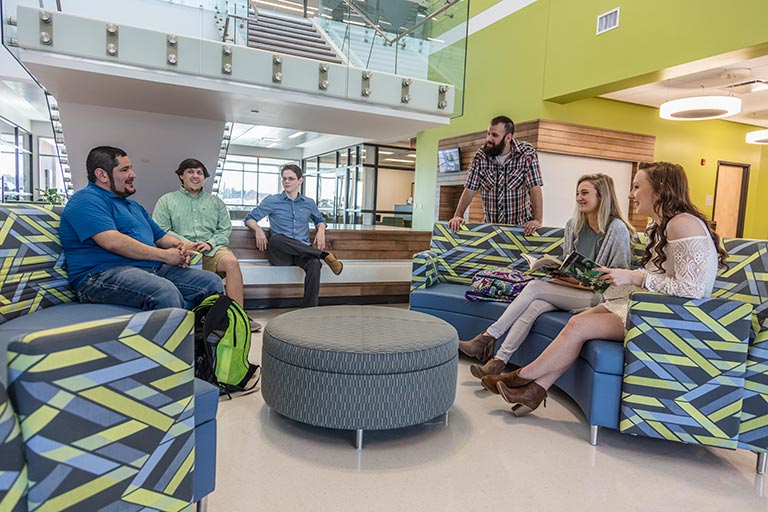 students standing or sitting on a couch talking