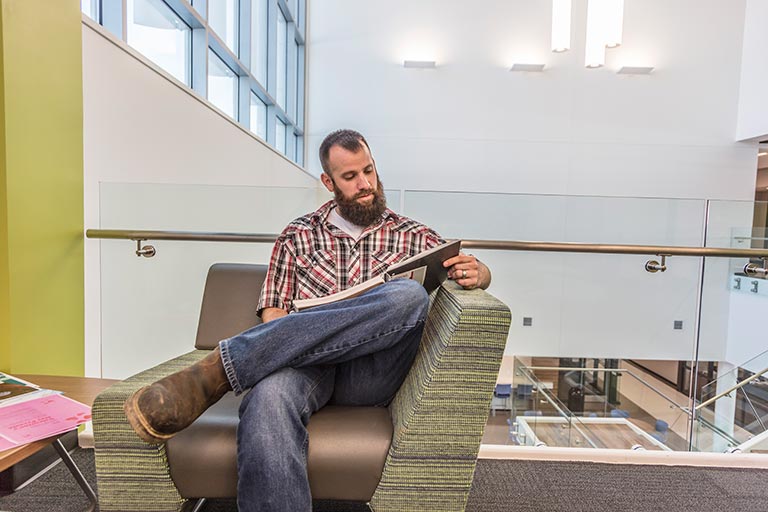 man looking through notes on a chair