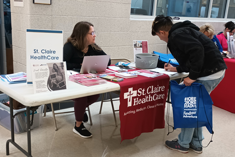 St. Claire Healthcare talking to sduent at a graduation event.